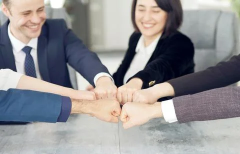 Unity and teamwork concept of young business people folding their hands together Stock Photos