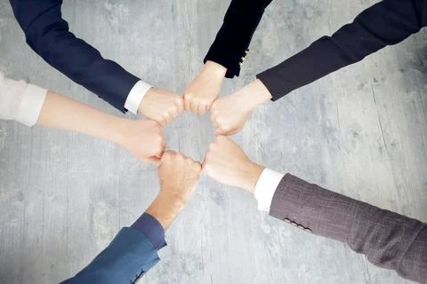 Unity and teamwork concept of young business people folding their hands together Stock Photos