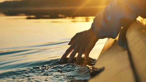 Unity with nature, man puts his hand into the water while sitting in kayak Видео 133319963