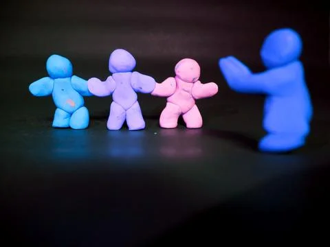 Unity is the power presenting buy three clay man cartoon on dark background Foto stock