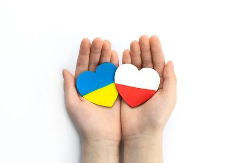 Unity solidarity help concept. Children's hands hold two hearts with flags of Foto stock