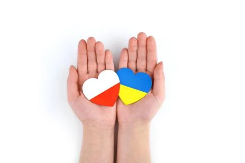 Unity solidarity help concept. Children's hands hold two hearts with flags of Stockfoto's