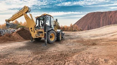 A universal excavator loader is digging and moving dirt at a construction s.. Stock Photos