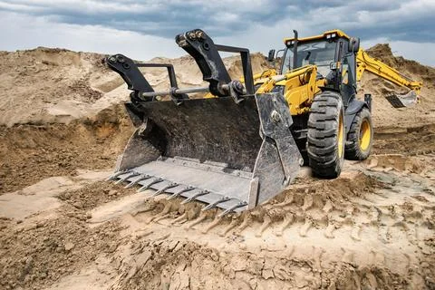 Universal excavator loader is performing work on a construction site. The m.. Stock Photos