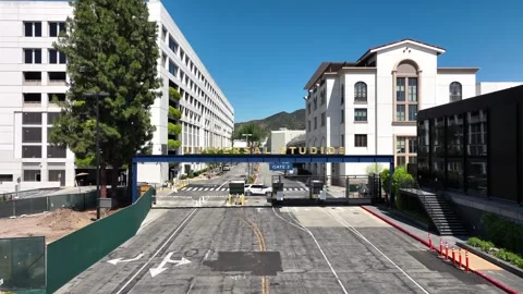 Universal Studios lot security gate empty entrance, aerial view low angle Stock Footage 240994958