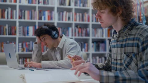 University Friends Studying Side by Side in a Library with Workbooks and 스톡 동영상 335124554
