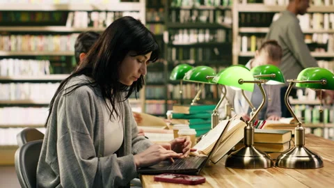 University student getting distracted by notification on phone while studying Stock Footage 336360719