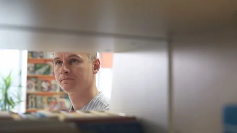 University student looking for a suitable book in a library Stock Footage 124530764