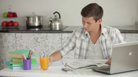 University student studying at table writing in notebook and looking at camera Stock Footage 27303055