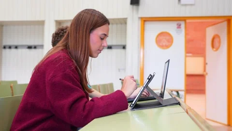 University student studying using a tablet in a classroom Stock Footage 347893296