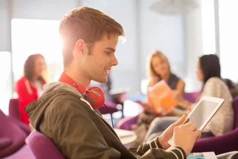 University student using digital tablet in lounge 스톡 사진