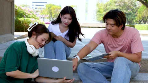 University Students Collaborating on Campus Steps with Laptop and Tablet Stock Footage 328786507
