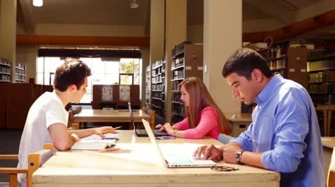 University students studying in the library central table Stock Footage 22384904