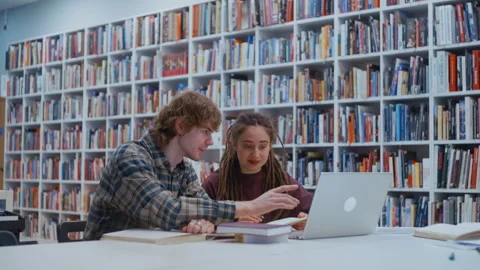 University students studying together in a library Stock Footage 335131376