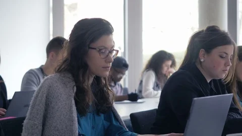University students taking notes in the notebooks and laptop computer Stock Footage 69932252