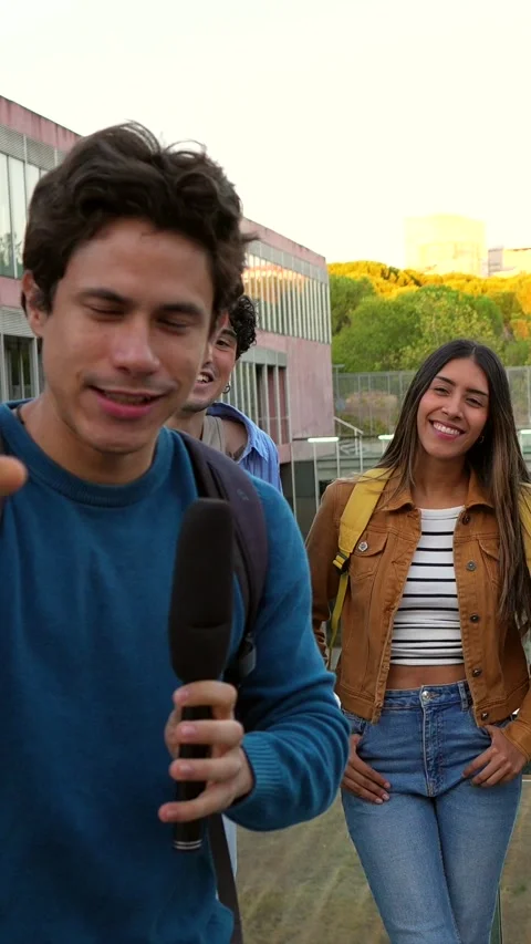 University students talking and laughing during an outdoor interview on campus Stock Footage 317849947