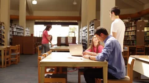 University students talking in the library central table Stock Footage 22384891