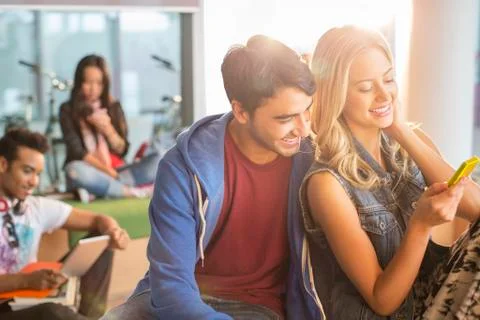 University students using cell phone in lounge 스톡 사진