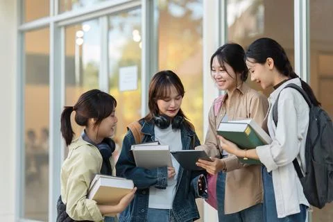 University students using a digital tablet while walking to next class Stock Photos