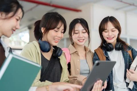 University students using a digital tablet while walking to next class Stock Photos