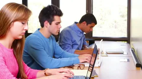 University students working on computers in the library near window Stock Footage 22410732