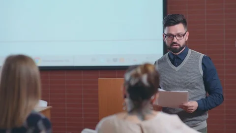 University teacher distributes to students the sheets of paper Vídeo Stock 88805873