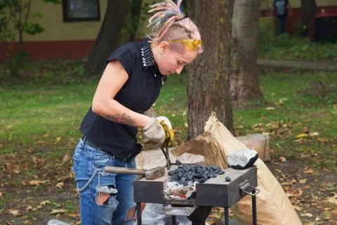 Unknown attractive girl as an apprentice blacksmith Stock Photos