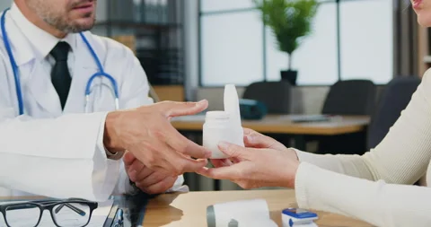 Unknown bearded professional doctor giving medicine to female patient during her Stock Footage 160790625