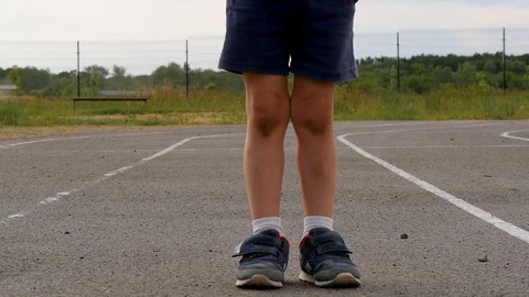 An unknown boy with dirty abrasions on his knees after the game is on the road Stockbeeldmateriaal 100268974