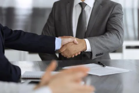 Unknown business people are shaking hands after contract signing in modern Stock Photos