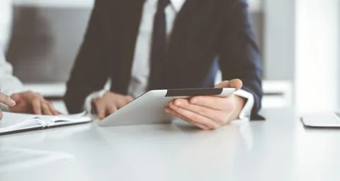 Unknown business people using tablet computer in modern office. Businessman or Stock Photos