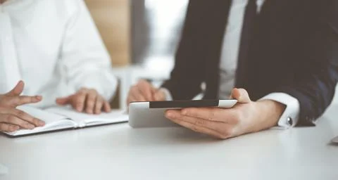 Unknown business people using tablet computer in modern office. Businessman or Stock Photos