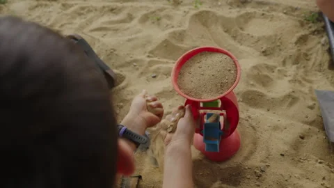 Unknown child playing in sandbox in the summer weekend. Kid playground. Sand Stock Footage 250309177
