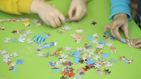 Unknown children collecting puzzles at the table Stock Footage 80930669