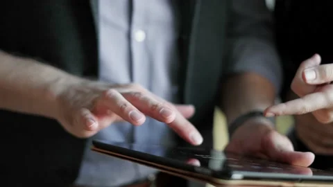 Unknown colleagues are using tablet computer and work together. Close-up Stock Footage 148328800