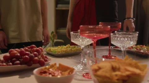 Unknown Couple Setting up Appetizer Table Showing Grapes, Canapes, Corn Chips Stock Footage 328245367