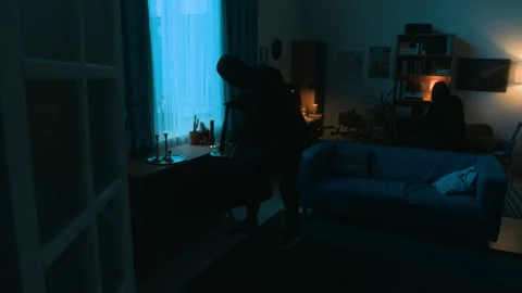 Unknown Criminal Stealing from Dark Room, His Partner Checking Bookcase Vídeos de archivo 292072495
