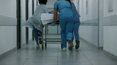 Unknown doctors team running hallway rolling gurney. Medics carrying stretcher. Stock Footage 194457223