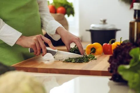 Unknown human hands cooking in kitchen. Woman is busy with vegetable salad Stockfoto's