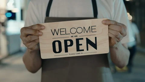 Unknown human showing board saying welcome we are open Stock Footage 303778733