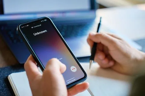 Unknown incoming call on smartphone during working at desk Stock Photos