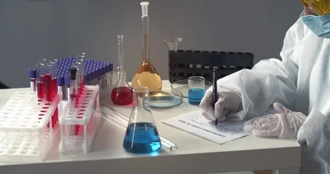 An unknown lab worker fills papers on coronavirus and is tired and fall asleep Stock Footage 129716425