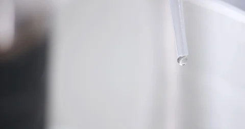 Unknown liquid drops out of a transparent tube Stock Footage 103321143