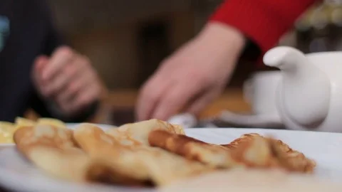 Unknown male person having breakfast in cafe, pancakes and tea with lemon Video stock 73610153