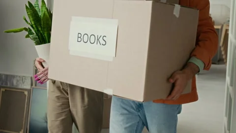 Unknown Man Carrying Boxes Putting Them on Floor, Girlfriend Walking beside Him Stock Footage 323297381