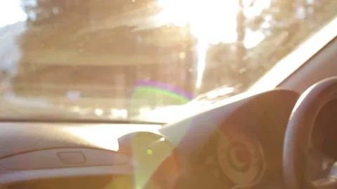 Unknown man driving a car through forest and rural area in winter under the sun Stock Footage 73616687