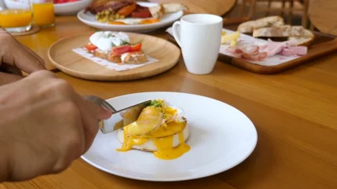 Unknown man eat poached egg benedict sandwich on breakfast in restaurant or cafe Vídeos de archivo 194237608