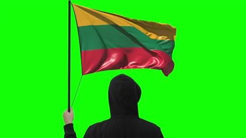 Unknown man holds waving flag of Lithuania, alpha matte Stock Footage 142751629