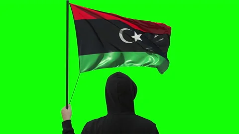 Unknown man holds waving flag of Libya, alpha matte Stock Footage 143205453