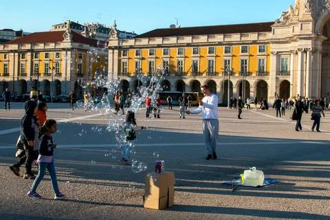 Unknown man playing with soap bubbles on the square in Lisbon. Stock Photos